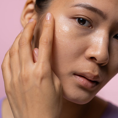 Woman applying clear serum to her face