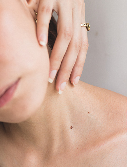 Closeup of a woman touching her face and neck