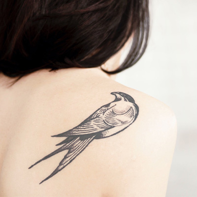 A bird tattoo on a woman's shoulder